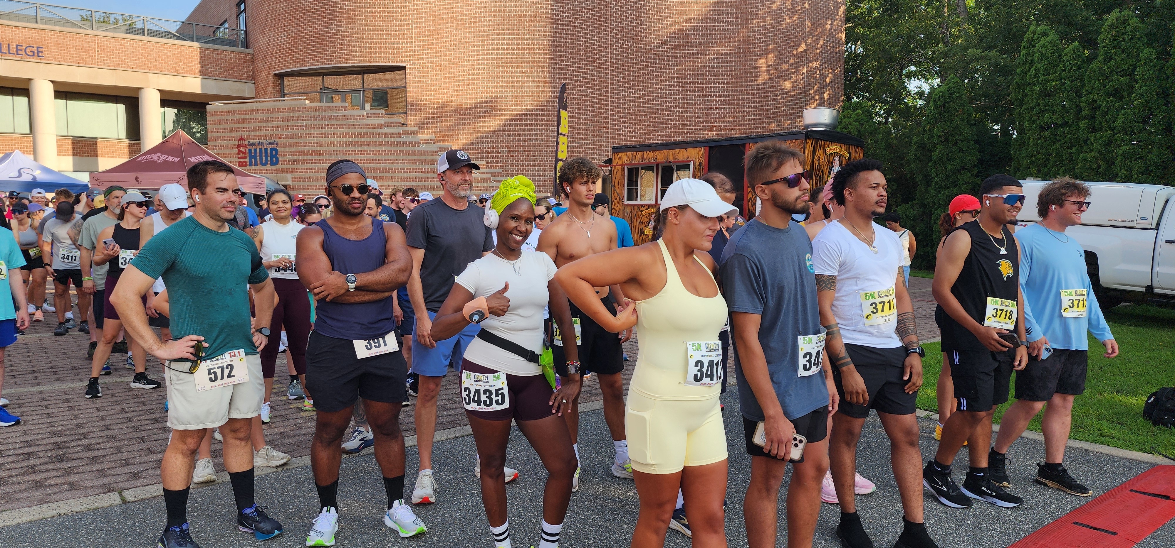 A row of runners wearing race bibs lined up at the start of the 2026 Jersey Shore Summer Half Marathon, 10K and 5K